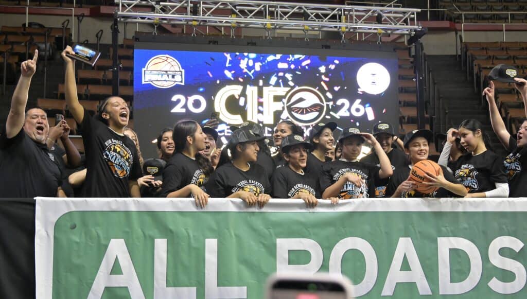 Photo of The Matilda Torres Toros girls basketball team celebrates on the stage after winning the 2026 Div. IV Central Section Championship with a 34-23 victory over the Tulare Union Tribe on Friday at Selland Arena. It’s the first basketball title for Torres.