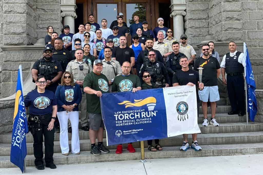 Photo - Members of the Madera Guardians stand with members of the Madera County Special Olympics on the steps of the Madera County Museum before the annual Torch Run on Wednesday.