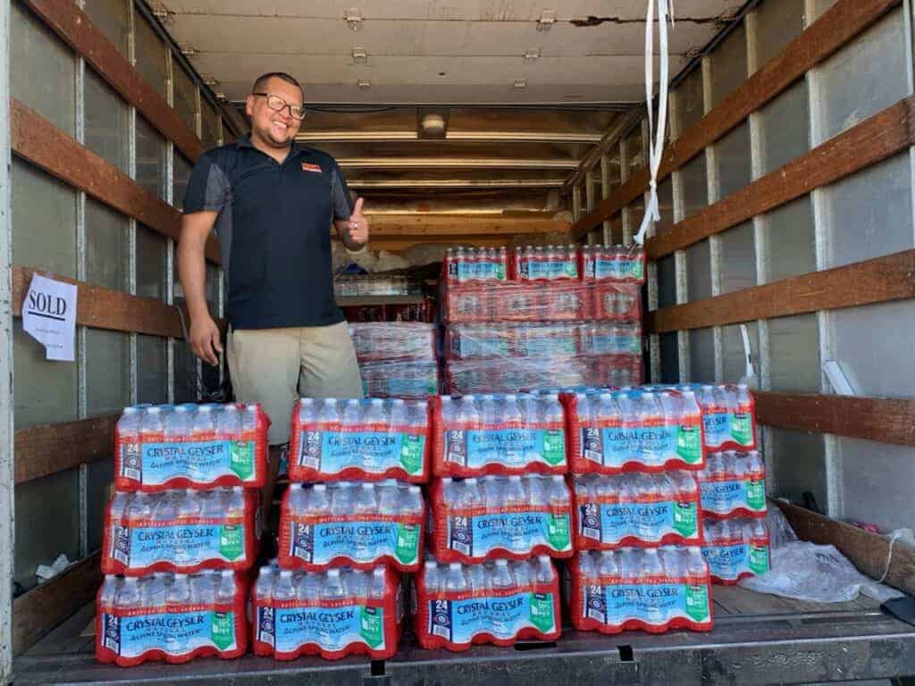 Photo - Togo’s Sandwiches owner Jose Carrillo shows off a full truck of water that he donated Tuesday to every elementary school in Madera Unified School District. He donated at least 25 cases of water to each school.
