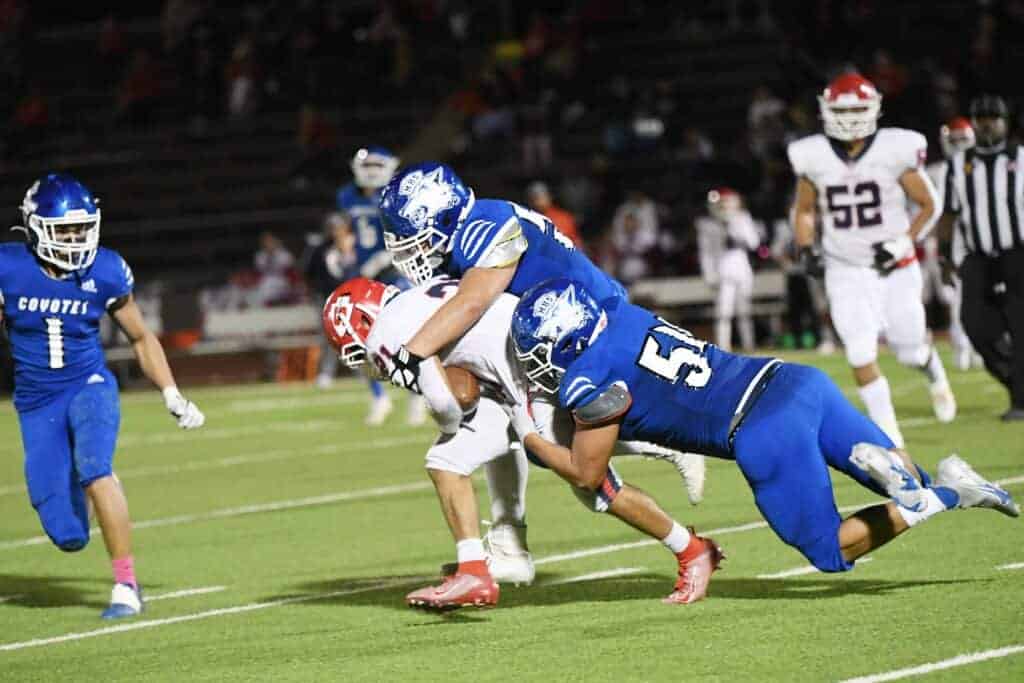 Photo - Jayson Ruiz and Julian Flores (54) make a tackle on a Sanger ball carrier.