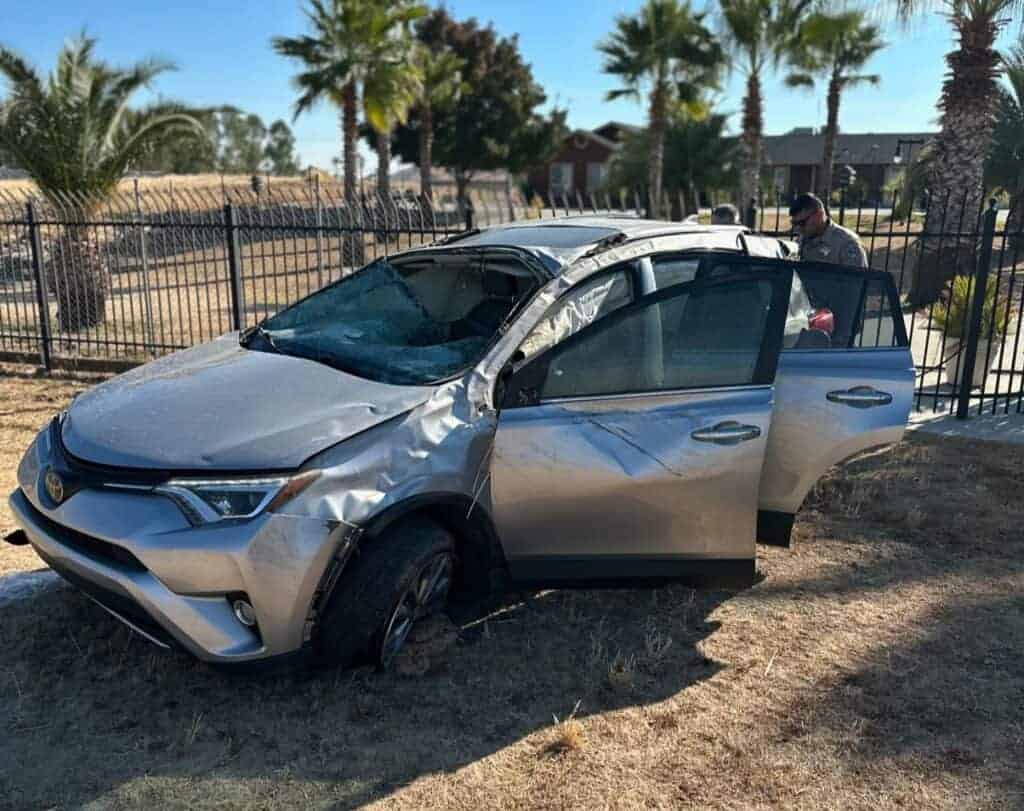 Photo - California Highway Patrol officers look at a Toyota RAV4 that was involved in a rollover crash after the driver fell asleep at the wheel, and over-corrected, causing the rollover.
