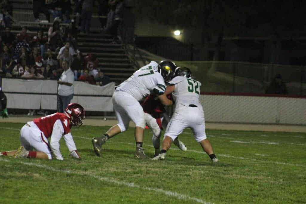 Photo - Liberty defensive linemen Francisco Rojas (77) and Nick Hayes (52) engulf Chowchilla quarterback Cody Woolsey during a third quarter sack Friday night.