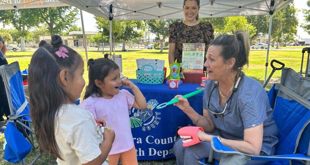 Photo - Rosalle Gonzales, 4, and Guadalupe Gonzales, 5,  are shown how to properly brush their teeth by Renee Brown RDHAP Dental Hygienist and Ahana Amezola of the Madera County Health Program.