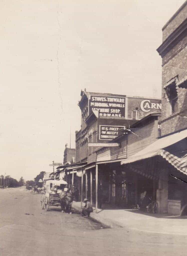 Photo - This view of South Yosemite Avenue at D Street, taken circa 1910, shows the single-story Bank Saloon, Madera Restaurant, and Cottage Saloon, standing between the First National Bank in the foreground and the two-story McCabe House.
