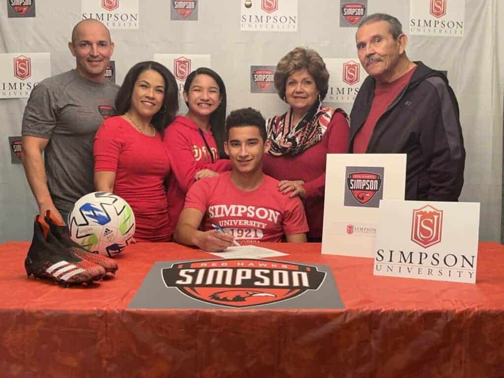 Photo - Madera’s Christian Valdez and his family are all smiles after he signed his National Letter of Intent to play soccer at Simpson University. Valdez, a starter with the San Joaquin Memorial Panthers, takes a 4.2 grade point average to Simpson.