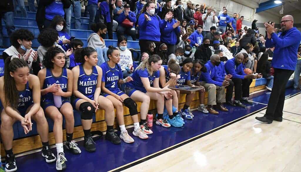 Photo - Members of the Madera Coyotes girls basketball team pass down the Div. IV Runner-up plaque after a tough loss in the Div. IV Championship game to the Corcoran Panthers.