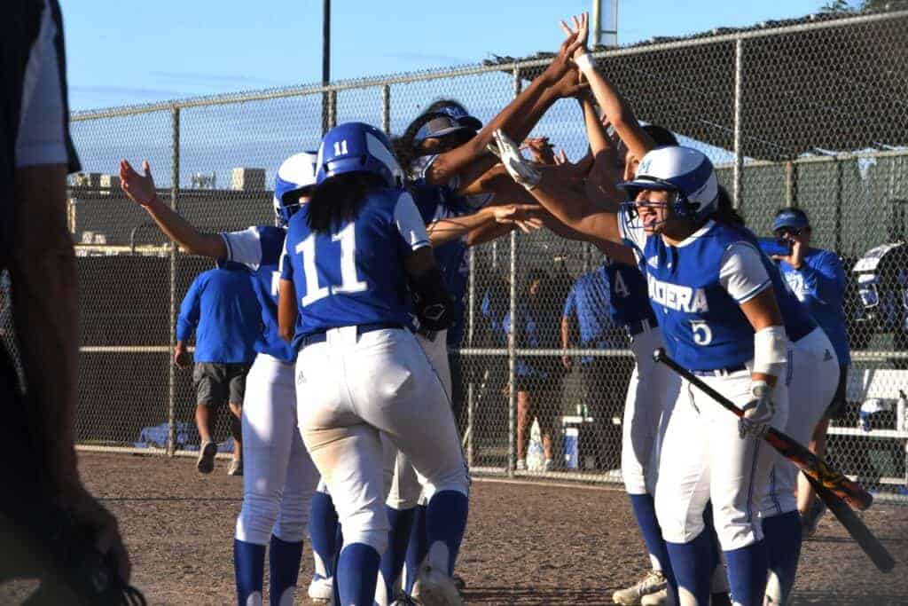 Photo - The Madera Coyotes softball team forms a tunnel for Erika Perez (11) to run through after she hit her second home run in Friday’s 13-0 victory over the Madera South Stallions.