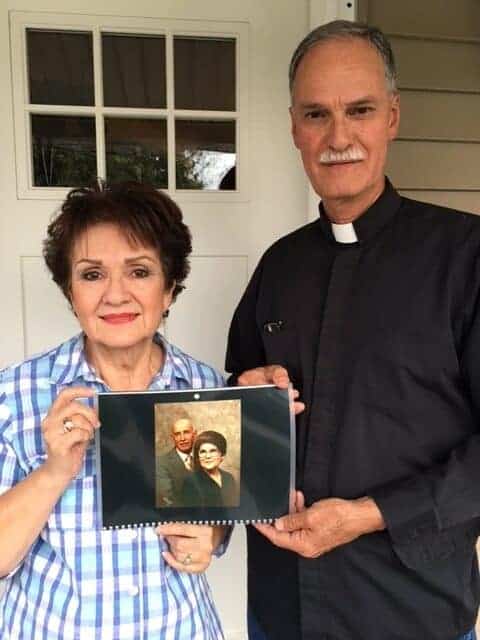 Photo - Siblings Hillary Ybarra and Fr. Carlos Esquivel Jr. show a photograph of their parents, who were longtime members of the Guadalupanos Society of Madera. The society will celebrate its 90th anniversary celebration Saturday at Holy Spouses Hall.