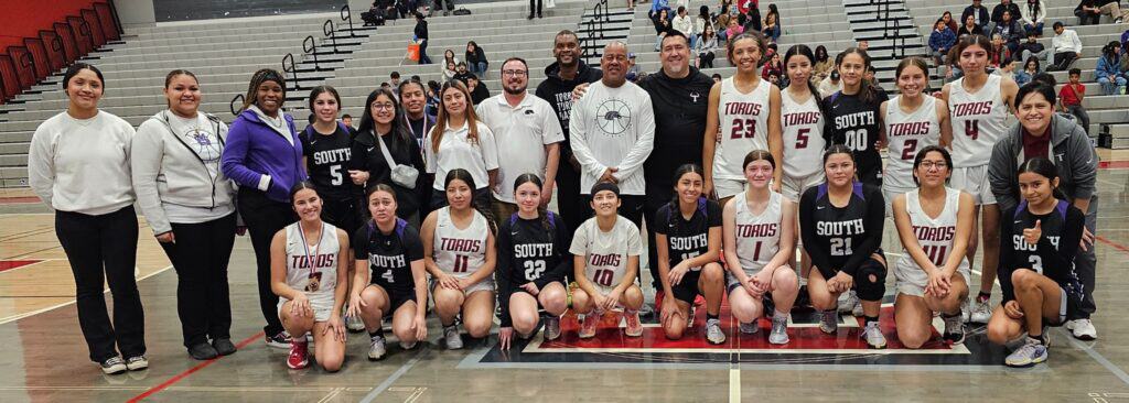 Photo - Matilda Torres Toros and Madera South Stallions girls basketball teams gather at center court in the Torres gym in a sign of Madera Unified unity after the Toros defeated the Stallions to win the Cen-Cal Holiday Basketball Tournament championship at Torres on Saturday.