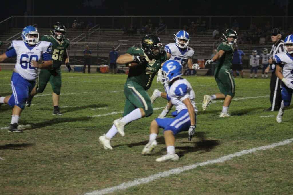 Photo - Liberty’s Caleb Sisco runs by a Caruthers defender during a long gain Friday night. He led the Hawks with 100 yards rushing in a 30-6 victory.