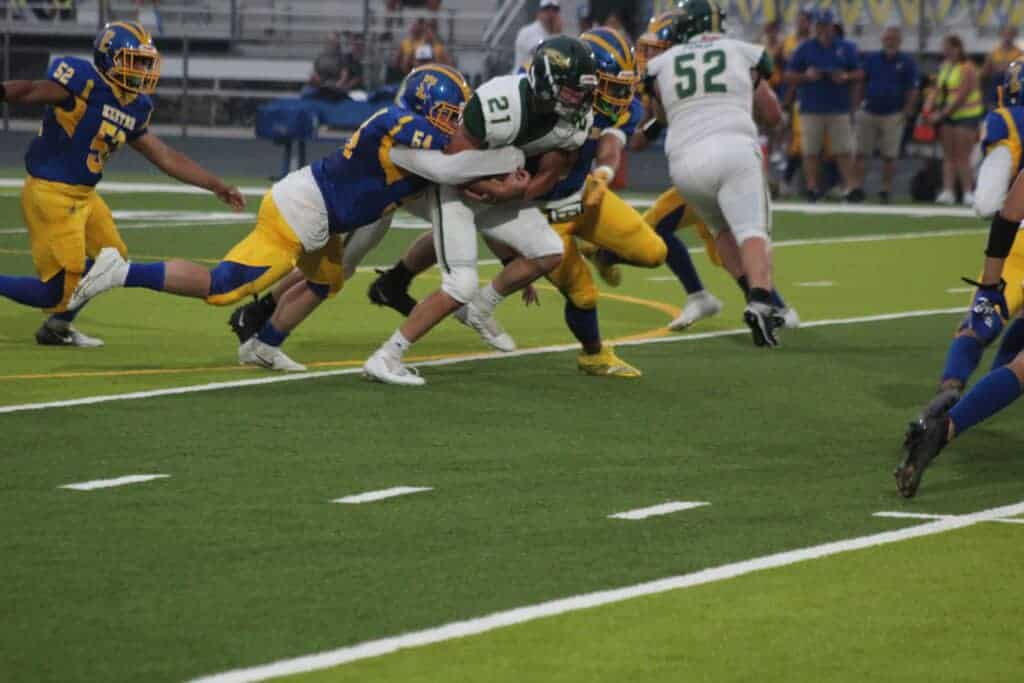 Photo - Liberty’s Mitchell Whaley holds onto the ball while gaining extra yards during Friday’s loss. He led the Hawks with 99 yards rushing and scored one of their two touchdowns.