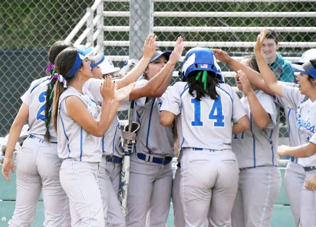Photo - Madera’s Taylor Brooks, left, and Haley Perez, right, congratulates Valerie Ornelas (14) after her fourth home run of the season in Tuesday’s loss to the Knights.