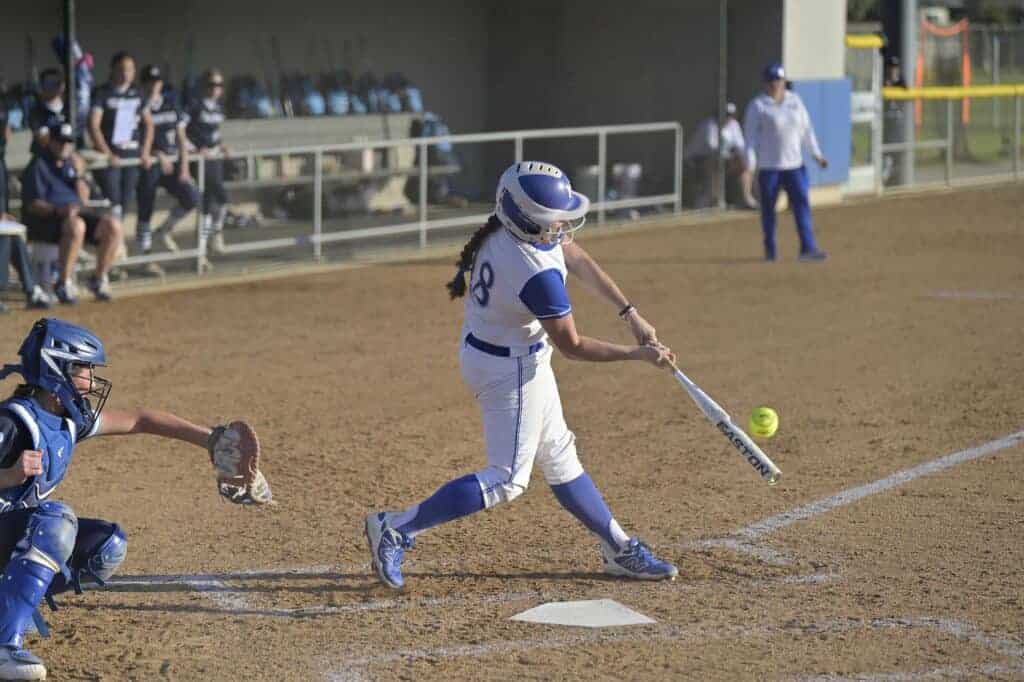 Photo - Madera’s Emily Erwin get a hold of a pitch to pull a double to left-center field that drove in a run during Wednesday’s 4-2 season-opening victory over Redwood.