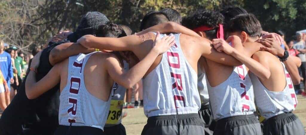 Photo - The Matilda Torres boys cross country team huddles together before the CIF Div. III State Championship race on Saturday in Woodward Park. The Toros ended up fifth. 