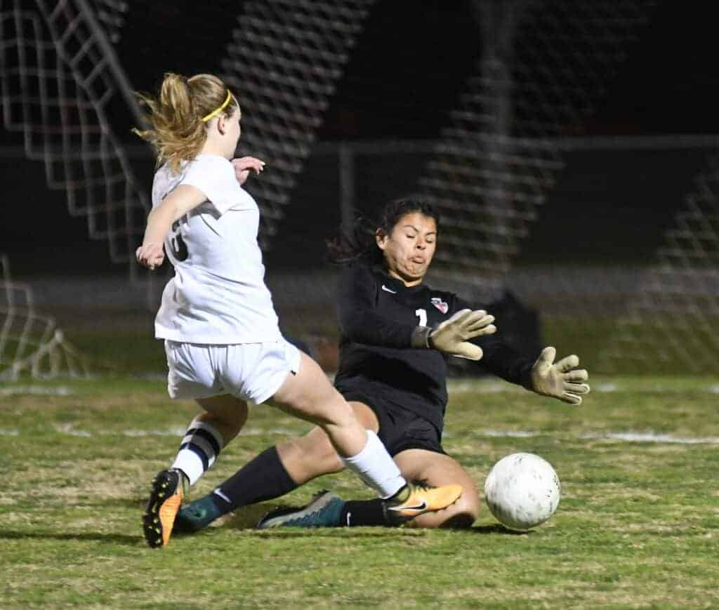 Photo - Liberty’s Brooke Wristen tries to slide a ball past the Sanger goalkeeper in the first half of Friday’s playoff game. Wristen got two shots past her in a 2-1 victory.