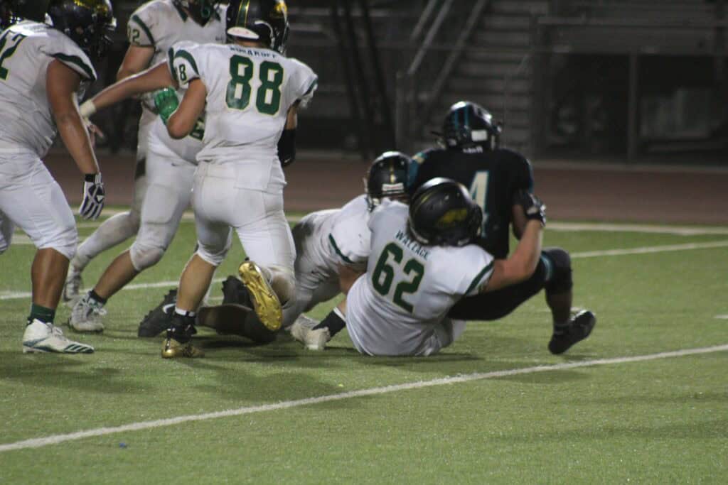 Photo - Liberty’s Brad Wallace brings down Kennedy’s Tyreak Walker for one of Walker’s 10 carries of three yards or less during Friday’s game.