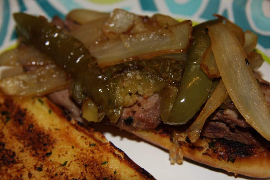 Photo - Load up some crusty garlic bread rolls with steak, onions, bell peppers and garlic.
