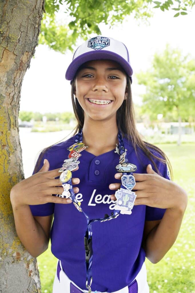 Photo - Madera National Little League All-Star Anna Rosales shows off pins she received when she was part of an elite group of girl Little League players to play in Williamsport last month. 