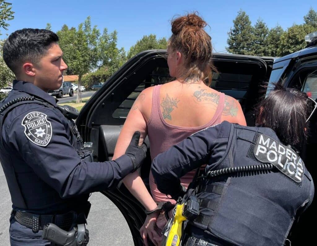 Photo - Madera Police officers make the arrest of Kristy Pettitt who was seen starting fires at Lions Town and Country Park and to a vehicle.