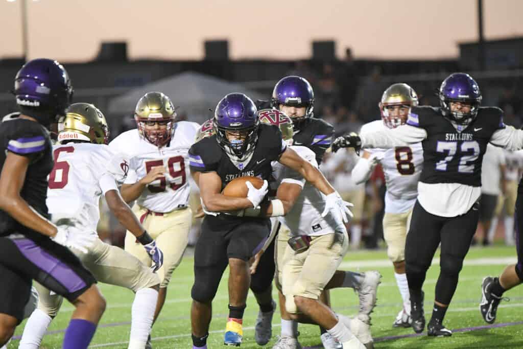 Photo - Madera South’s Angelo Moreno bursts through a hole for positive yardage during Friday’s loss to the Golden Valley Cougars. Moreno led the Stallions with 117 yards rushing.