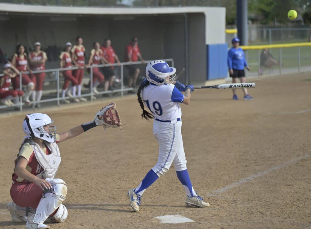 Photo - Madera’s Marisa Rincon flies a ball into left-center just beyond the reach of the shortstop for a single to drive in the go-ahead run in Thursday’s 4-3 victory over Centennial at Zimmerman Field. 