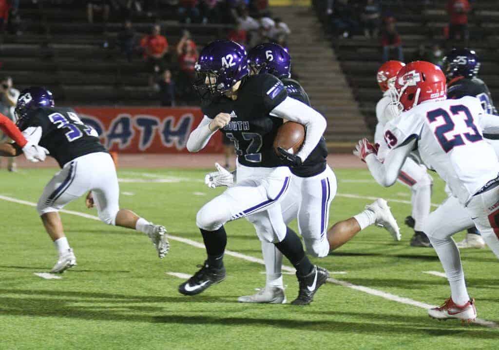 Photo - Madera South running back Dallas Hansen takes the ball up the field during Friday’s loss to the Sanger Apaches.