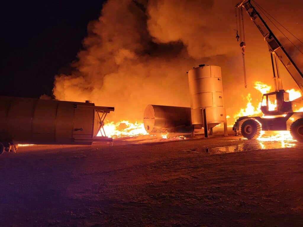 Photo - Fire sweeps toward a crane at Riley’s Brewing on Tuesday night. The brewery was destroyed.