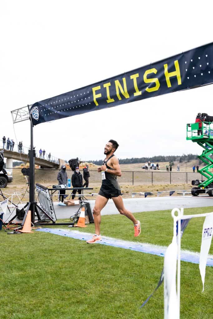 Photo - A smiling Eduardo “Lalo” Herrera crosses the finish line to win the Pac-12 cross country championship on Friday in Tacoma, Washington. The former Madera South standout won the race by 11 seconds.