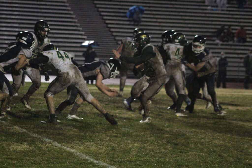Photo - Liberty’s Anthony Salas eludes a Yosemite tackler while Max Nulick (44) provides a block during his 10-yard touchdown run to close the scoring of Friday’s 54-7 victory over the Badgers.
