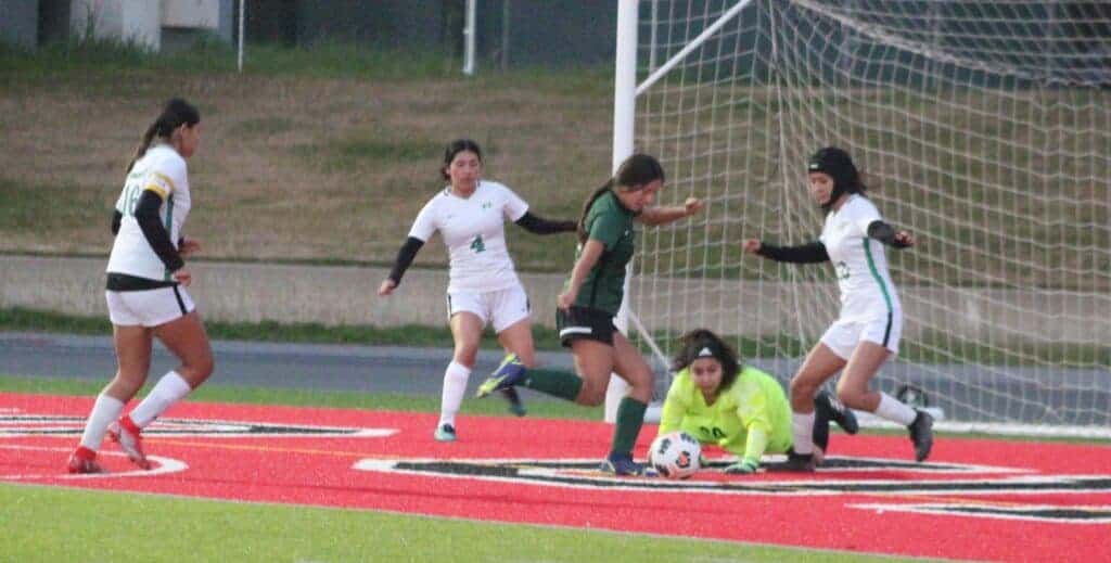 Photo - With the Roosevelt goalkeeper and defender closing in, Liberty’s Marissa Lopez shoots the ball into an empty net for the lone goal of Saturday’s match with the Rough Riders.