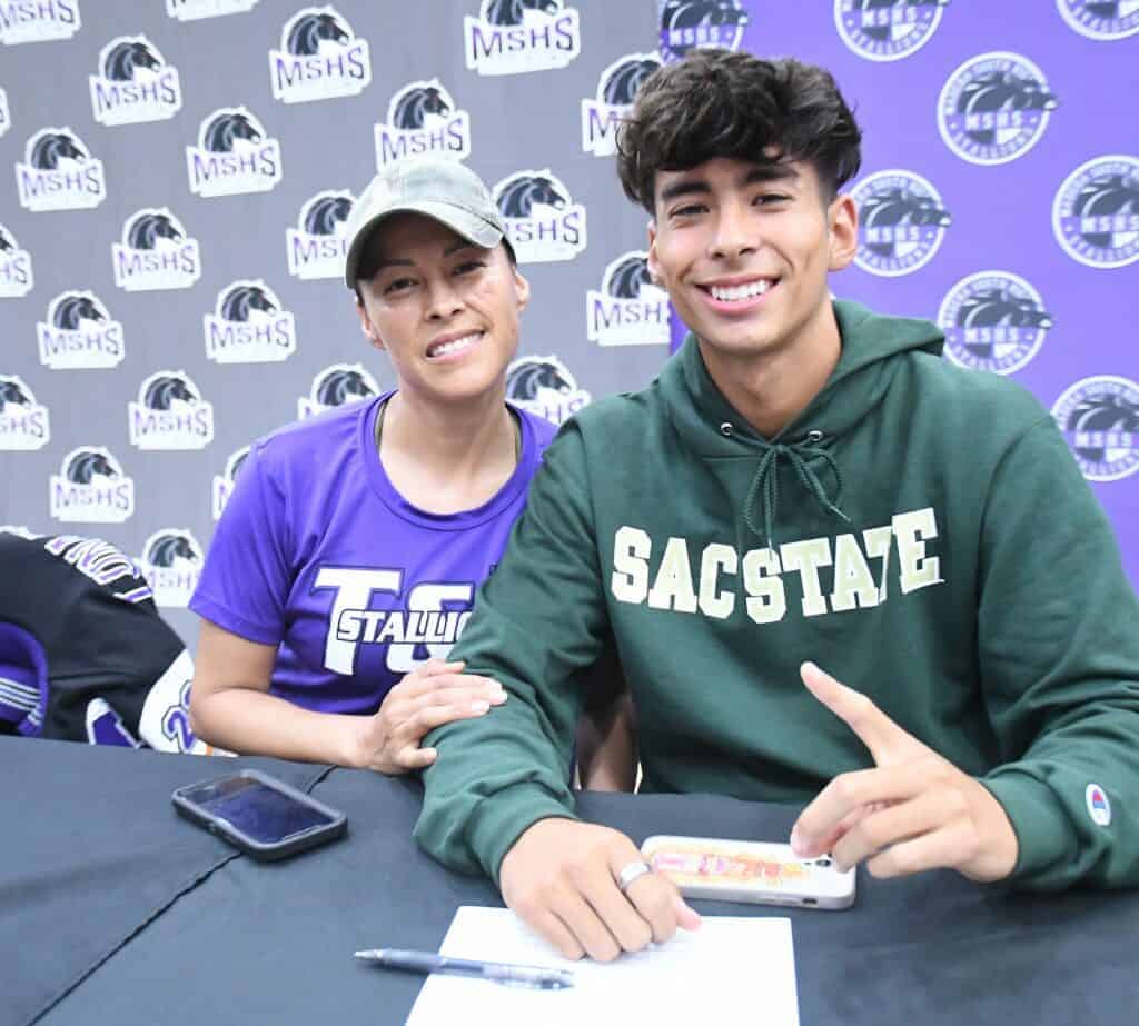 Photo - Madera South cross country and track runner Isaac Chavez and his mother Eloisa are all smiles after he signed a National Letter of Intent to Sacramento State.