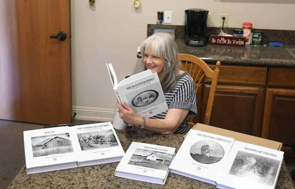 Photo - Nancy Simpson looks at a series of Madera Method books that will be donated to school libraries.