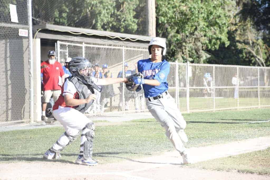 Photo - Madera American’s Matthew Castaneda looks to be tagged out on a play at the plate. However, the glove was empty as the throw was missed to allow Castaneda to score the second run of a 5-0 victory Friday against Chowchilla. 