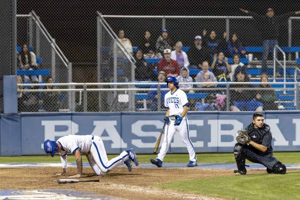 Photo - Madera’s Benji Molina stands up after sliding home to score the game-tying run in the fifth inning of Thursday’s 11-6, eight-inning victory over Madera South. Joel Arellano approaches to help Molina up while Madera South catcher Xavier Cantu watches the action.