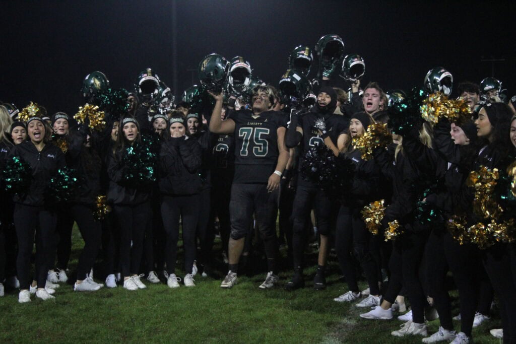 Photo of The Liberty Hawk football players and cheerleaders sing the school’s Alma Mater for the last time this season after Friday’s semifinal playoff loss to Bishop Union. 