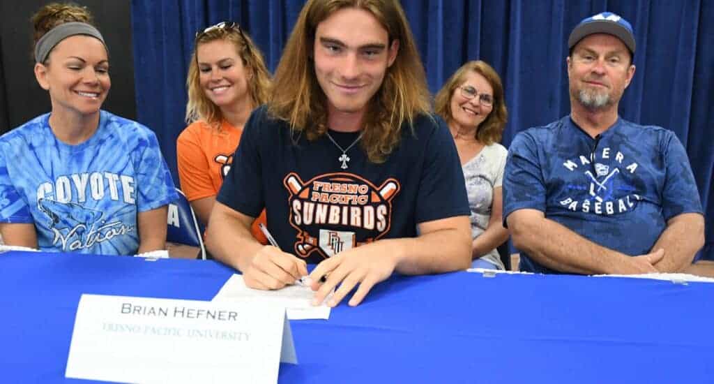Photo - With his family watching, Madera Coyotes baseball player Brian Hefner, middle. signs his National Letter of Intent to Fresno Pacific University in 2018. From left are are mother Suzy, sister Brielle, Hefner, grandmother Anna Hardy and father Brian.