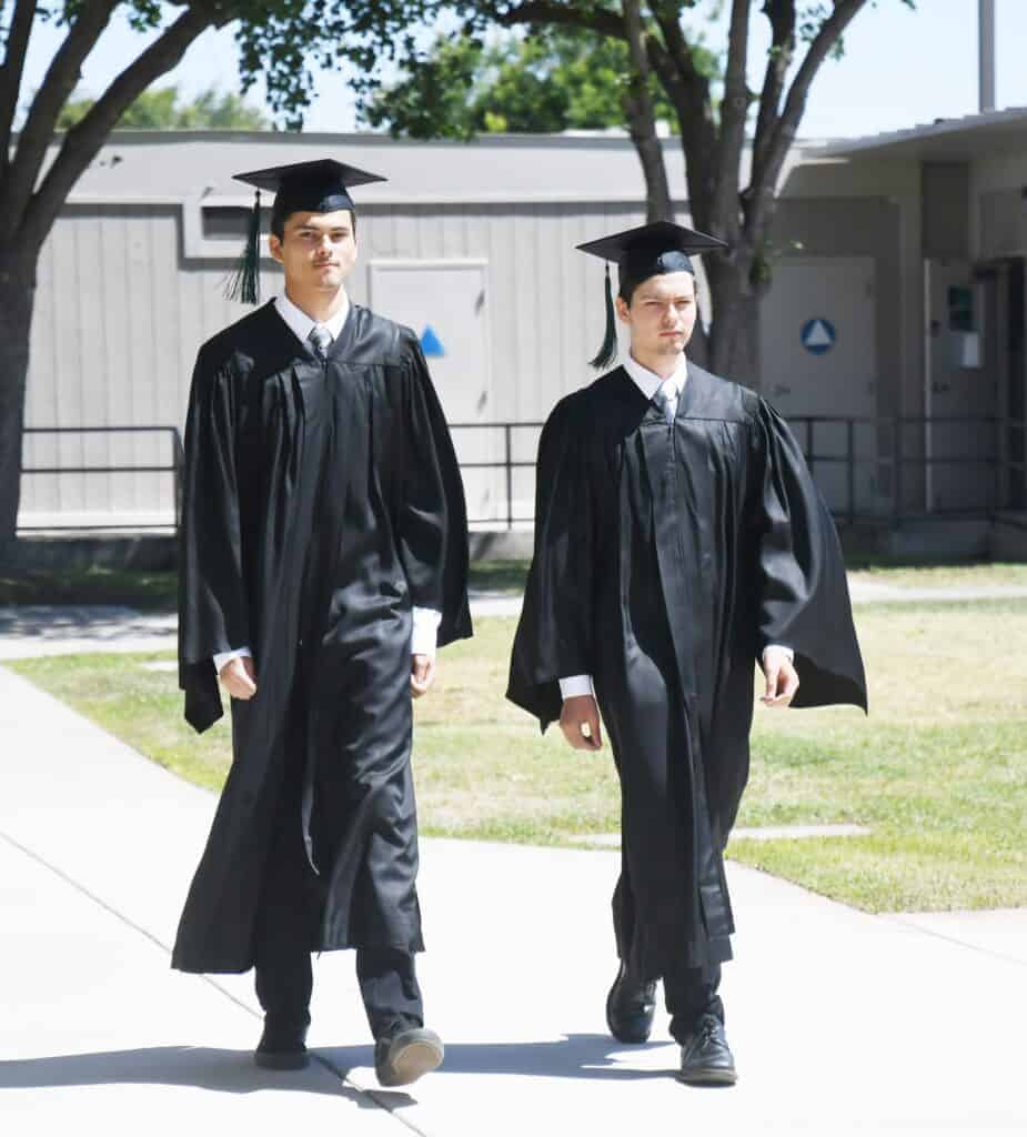 Photo - Brothers Mahonri, left, and Manasseh Montuy, walk together for their high school graduation ceremony from Pioneer Technical Center on June 10.