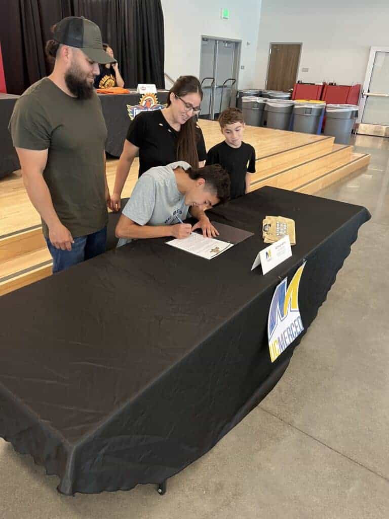 Photo - Matilda Torres’ Buffalo Soito is surrounded by his family while signing to run cross country and track at UC Merced. He is the first Torres male cross country runner to run for a four-year college.