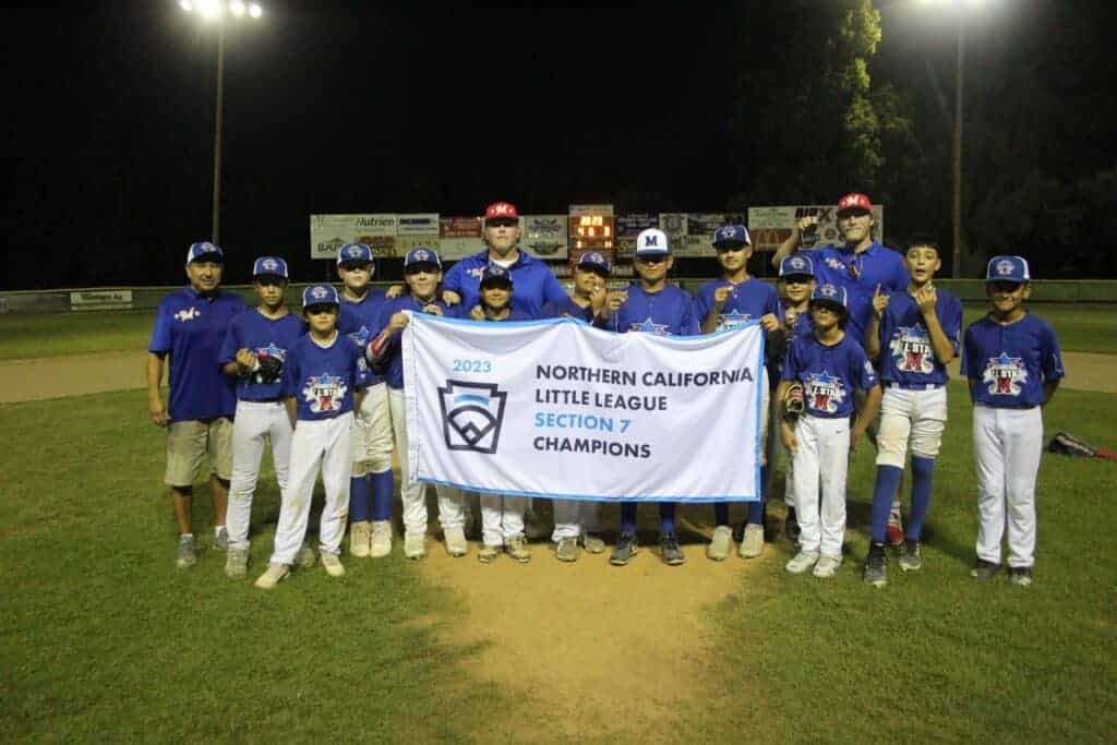 Photo - The Madera American Little League 12-year-old All-Star team celebrates with the Section 7 banner after capturing the championship following a 4-3 victory Saturday over Arvin. The All-Stars will next play in Stockton for the State Championship.