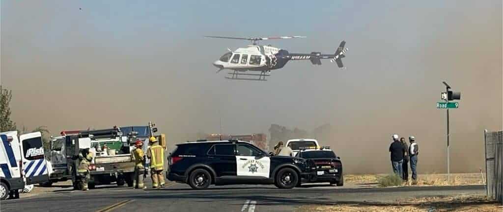 Photo - A medical helicopter flies over a vehicle crash site on Avenue 25 and Road 9. The crash left three with major injuries and were transported to Community Regional Medical Center.