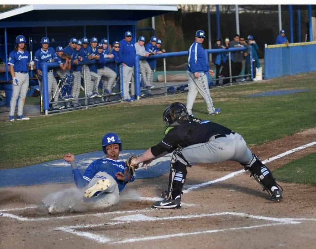 Photo - Madera’s Jerry Hernandez slides under the tag of to score a second inning run in Tuesday’s loss to Clovis North.