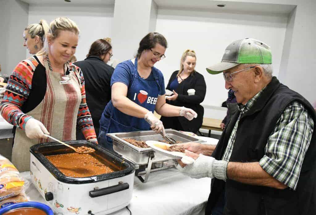 Photo - Betsy Cardoza, left, and Stacy Miles serve Ben Samper during the annual Madera County Cattlewoman’s annual Chuck Wagon luncheon Thursday.