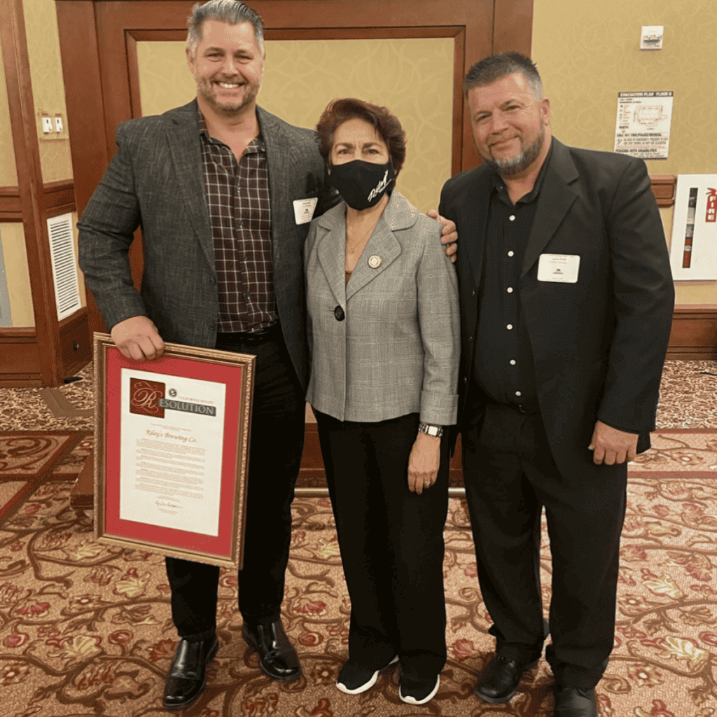 Photo - Riley’s Brewing owner Dan Riley shows off the 2021 California Small Business of the Year award from California State Senator Anna Caballero. Riley’s production manager Jason Webb was also present for the award presentation.