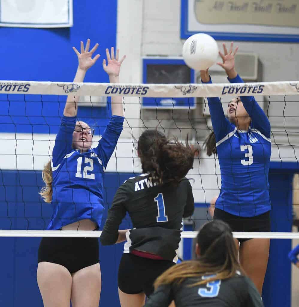 Photo - Madera’s Elizabeth Corchado (12) and Isabella Saucedo (3) go up to block an Atwater attack. Saucedo led the Coyotes with 12 kills in the four-set win.