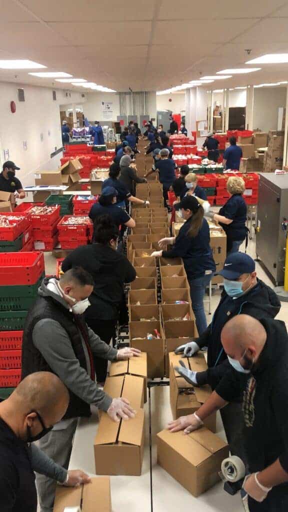 Photo - The Madera Unified School District Child Nutrition Department’s production line fills boxes of food for students.