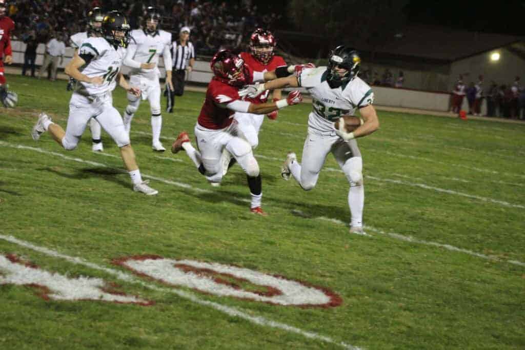 Photo - Liberty’s Wyatt Roth sheds a Chowchilla tackler during a record-breaking performance in Friday’s victory to help give the Hawks the North Sequoia League championship.
