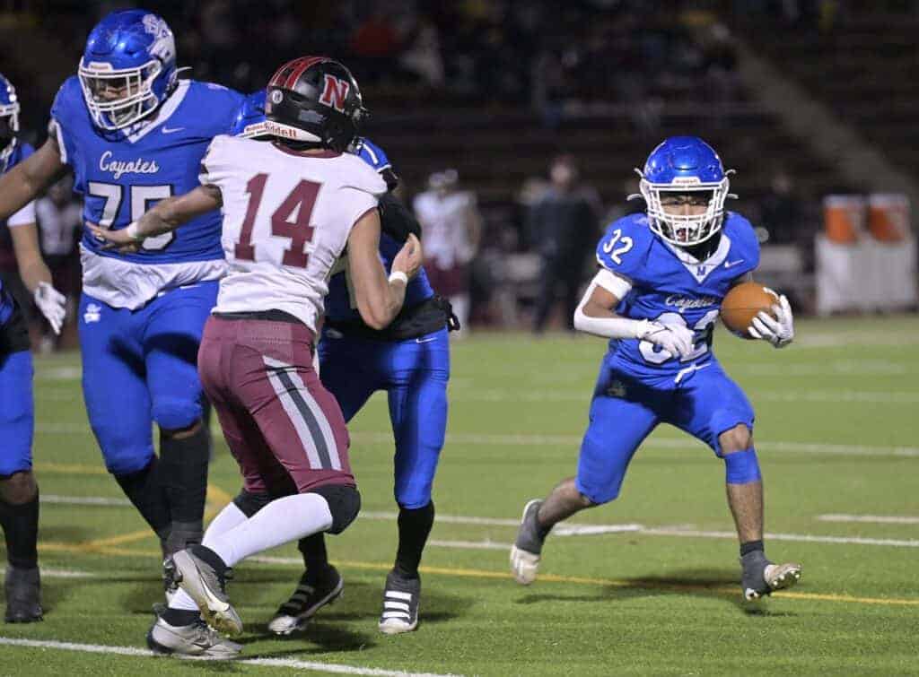 Photo - Madera’s Jesse Rodriguez (32) looks for running room behind Issaiah Beas (75) and Kenji Tiscareno (7) during Friday’s playoff victory. Rodriguez rushed for 210 yards and two touchdowns in the win.