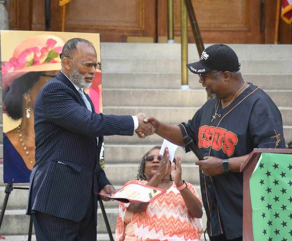 Photo - Pastor Sammy Neely, right, presents Stanley Mackey with a certificate of appreciation, on behalf on Mackey’s father, Cpl. Wilson Mackey, who served in the military as a Buffalo Soldier. The presentation was made during the Juneteenth Celebration at Courthouse Park on June 17.