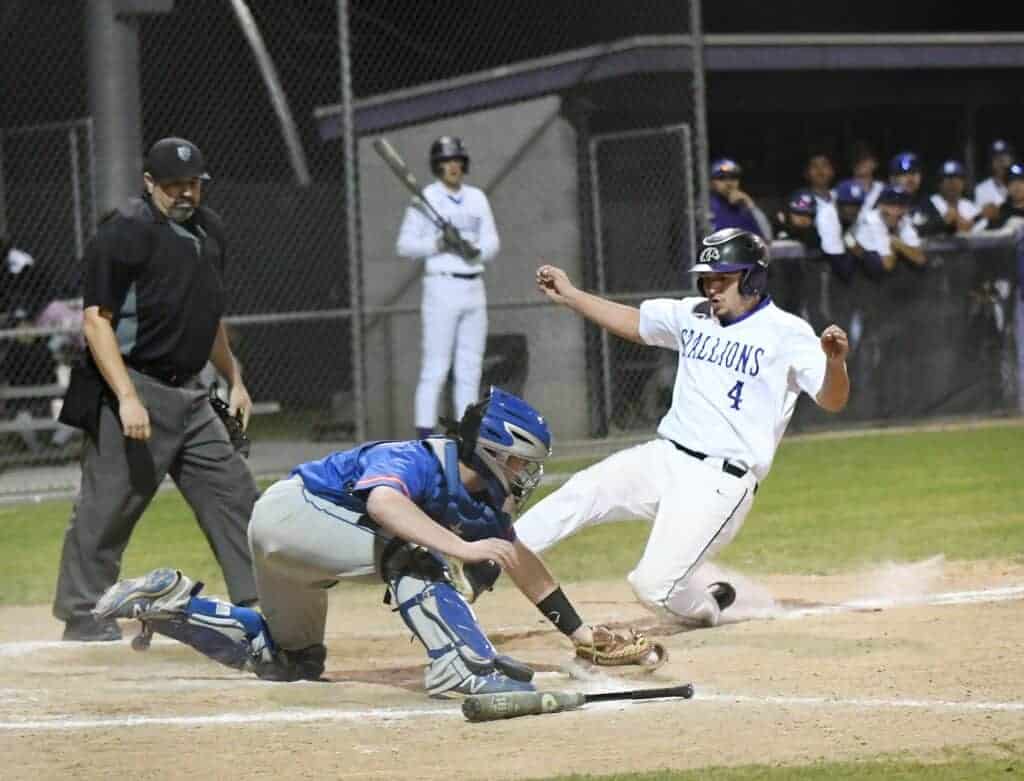 Photo - Madera South’s Xavier Cantu appears to have slid in ahead of the Immanuel tag at the plate in the fourth inning of Wednesday's 7-1 victory. However, he was called out for the second out of the inning.
