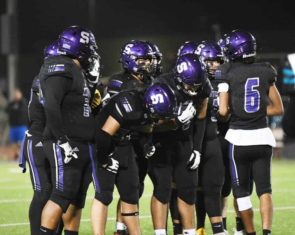 Photo - Madera South quarterback Jacob Edwards tells the offensive huddle the play during Friday’s Div. IV first-round playoff loss to the Mendota Aztecs.